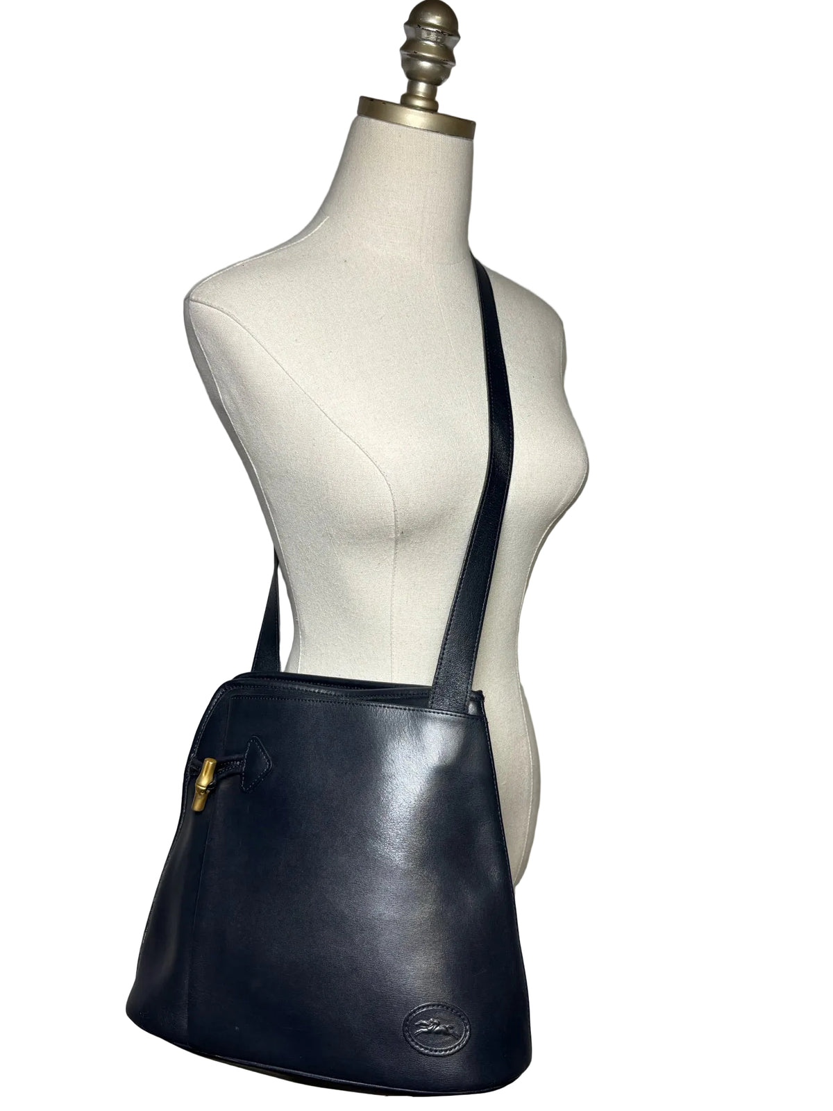 Navy Longchamp purse on a mannequin.