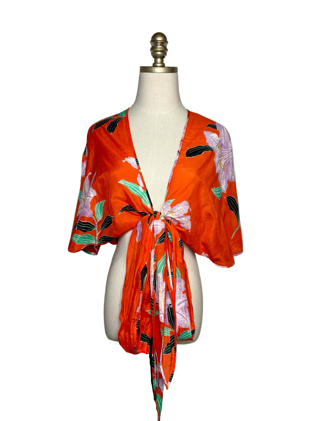 Red wrap top with a large purple flower design on a mannequin.