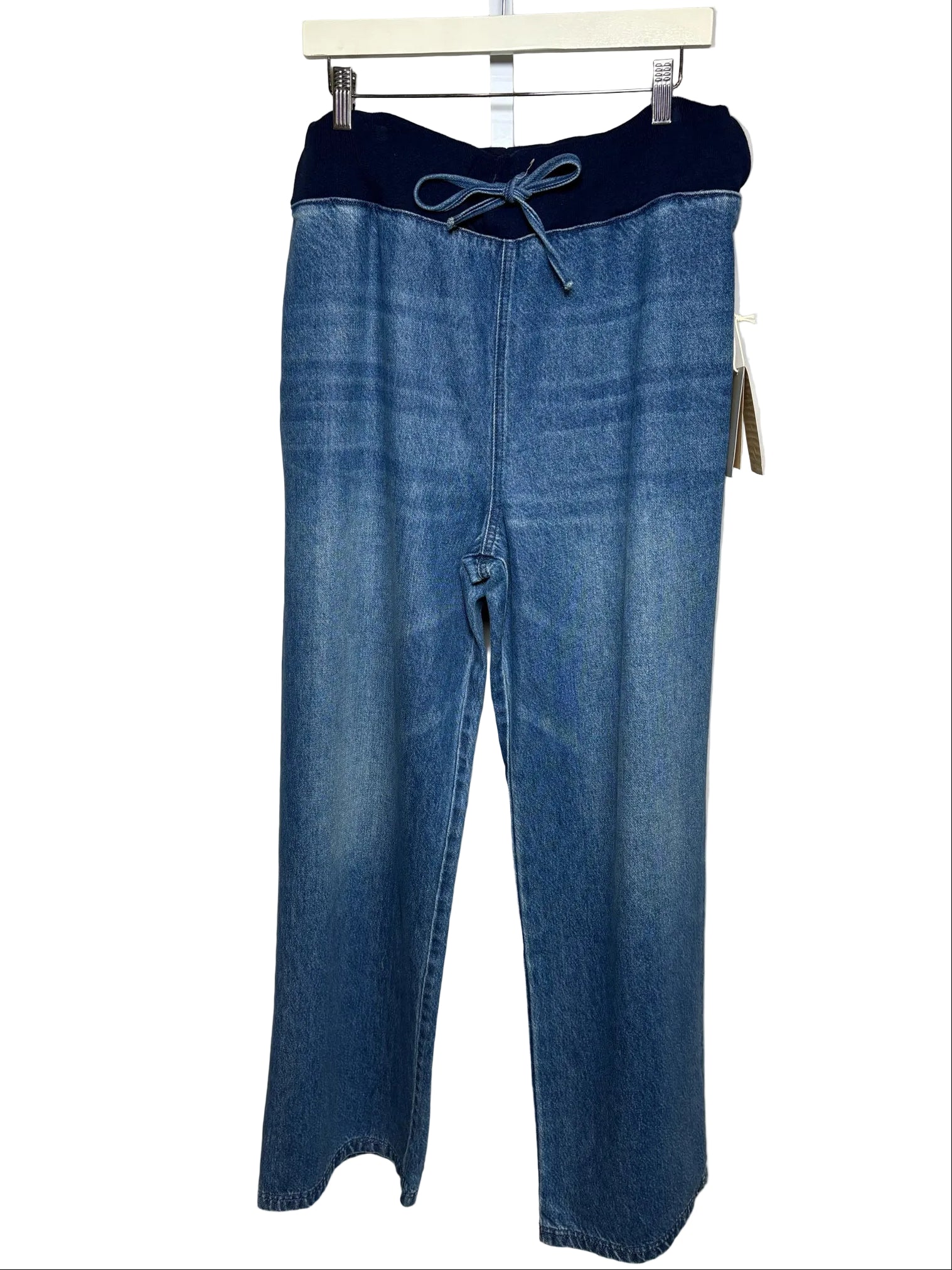 Blue denim wide-leg pants with a contrasting dark navy elastic waistband and drawstring, hanging on a white hanger against a white background.