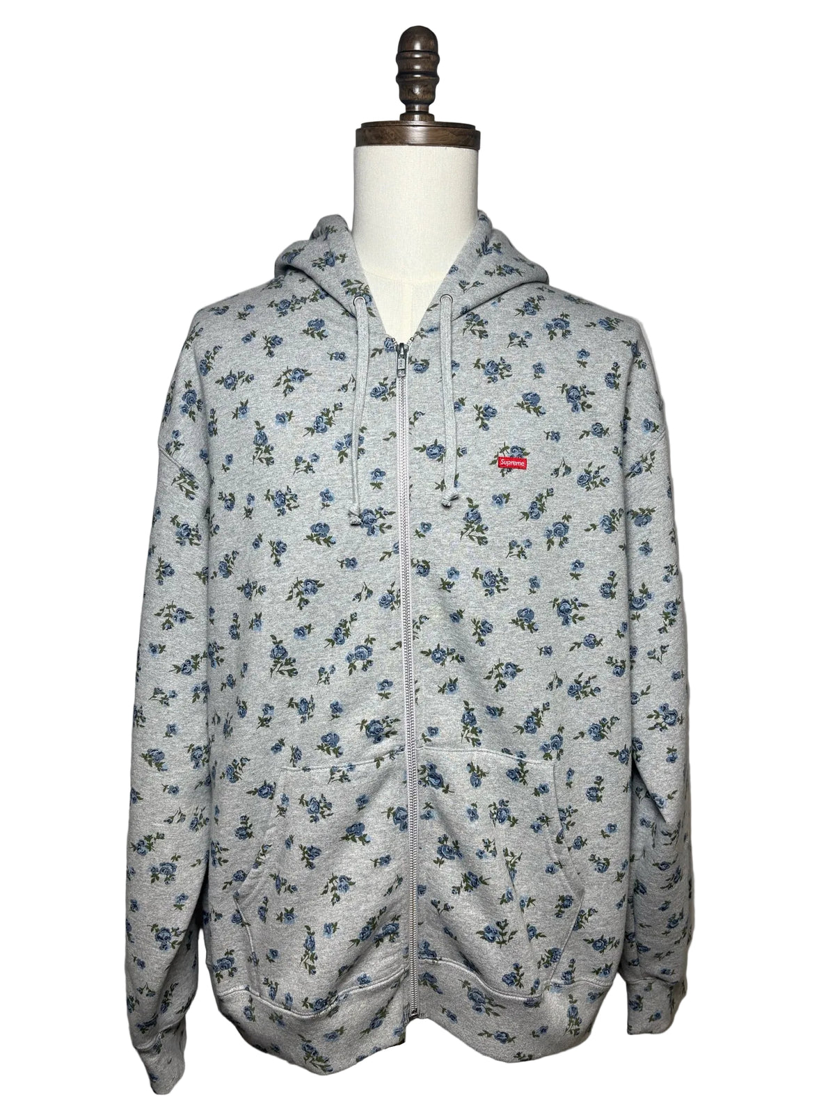 Grey Supreme hoodie with blue floral pattern and a red Supreme logo on left chest