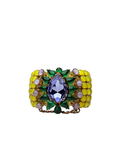 Gemstone cuff with small yellow stones on the sides and then green stones surrounding a central purple teardrop stone.