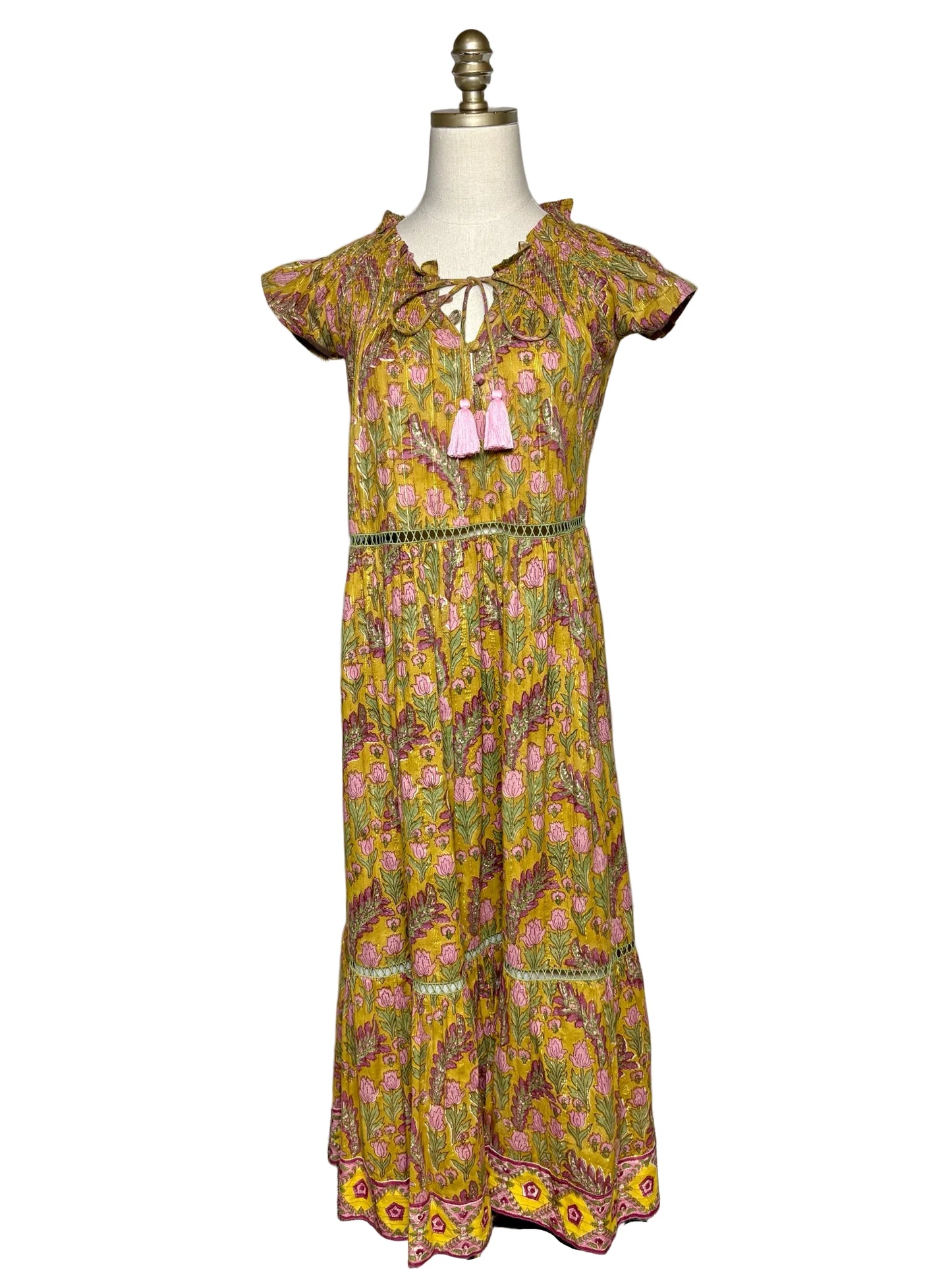 Green, pink, gold floral dress on a mannequin on a white background