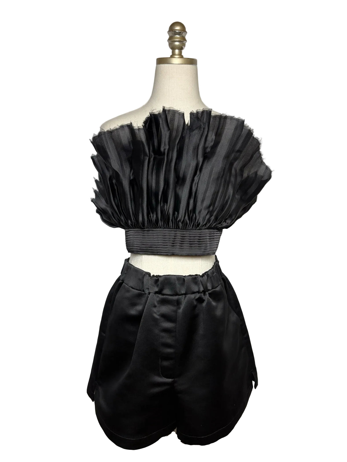 Mannequin wearing a black strapless silk top with black silk shorts.