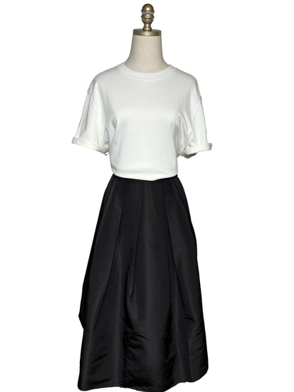A white t-shirt and a black a-line skirt on a mannequin.