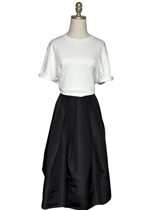 A white t-shirt and a black a-line skirt on a mannequin.