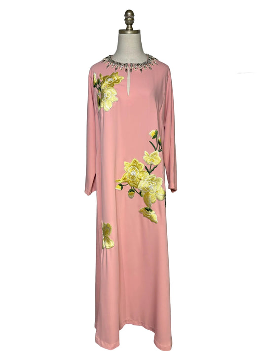 Long light pink dress with long sleeves and yellow floral embroidery.  The dress has a crystal embellished neckline and is on a mannequin in front of a white background.