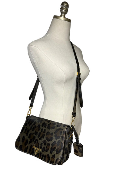 Leopard print crossbody Prada bag on a mannequin.