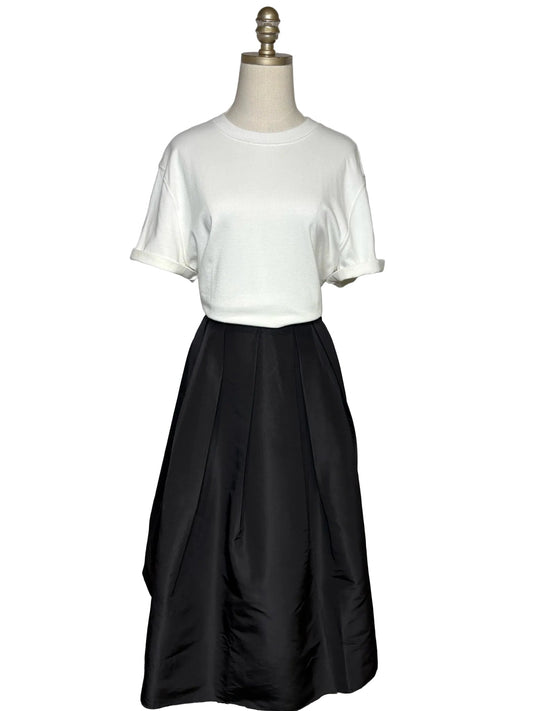 A white t-shirt and a black a-line skirt on a mannequin.